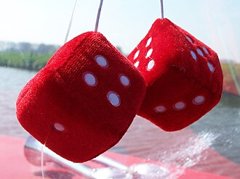 Deux dés en peluche rouges suspendus à un rétroviseur, porte-bonheur de joueur